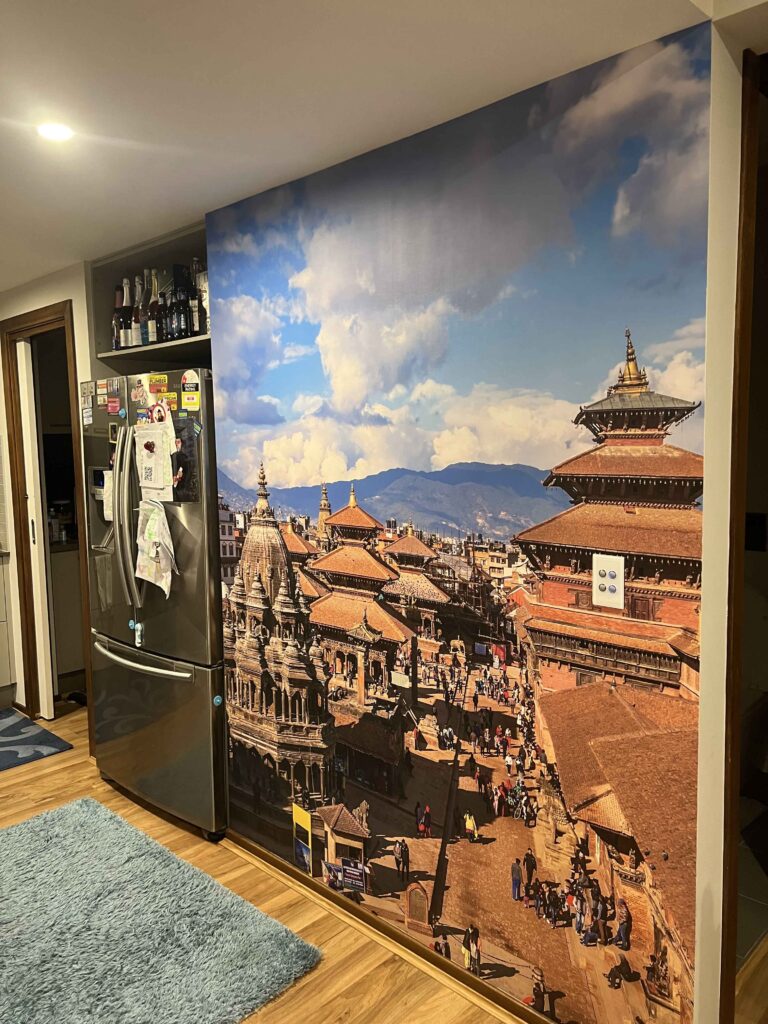 Fridge with a large mural of a bustling city street scene on a wall.