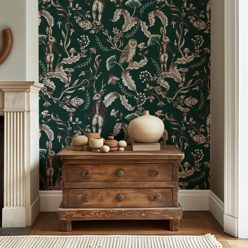 Wooden dresser with decorative items against a dark green wallpaper with animal patterns