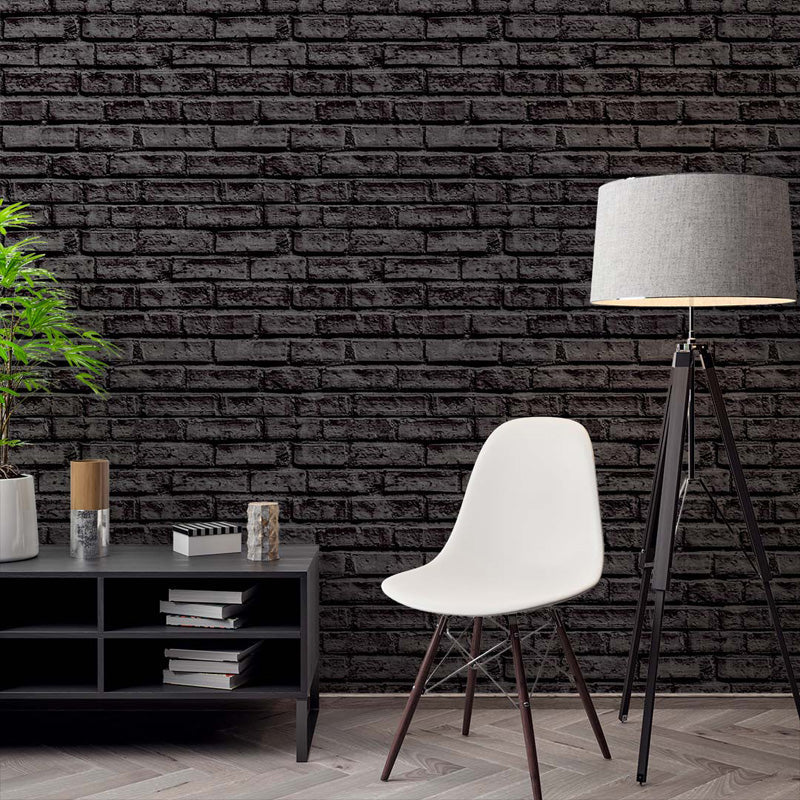 Modern interior with a black brick wallpaper, white chair, and decorative items.