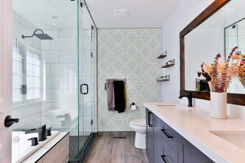 Modern bathroom with glass shower enclosure, vanity, and a classic wallpaper.