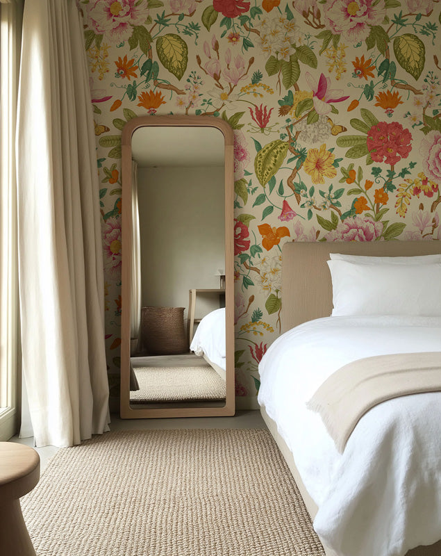 Bedroom with floral wallpaper, bed, mirror, and curtains.