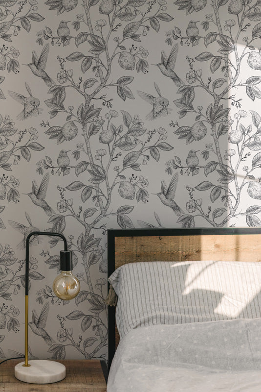 Bedroom with floral wallpaper, bed, and lamp