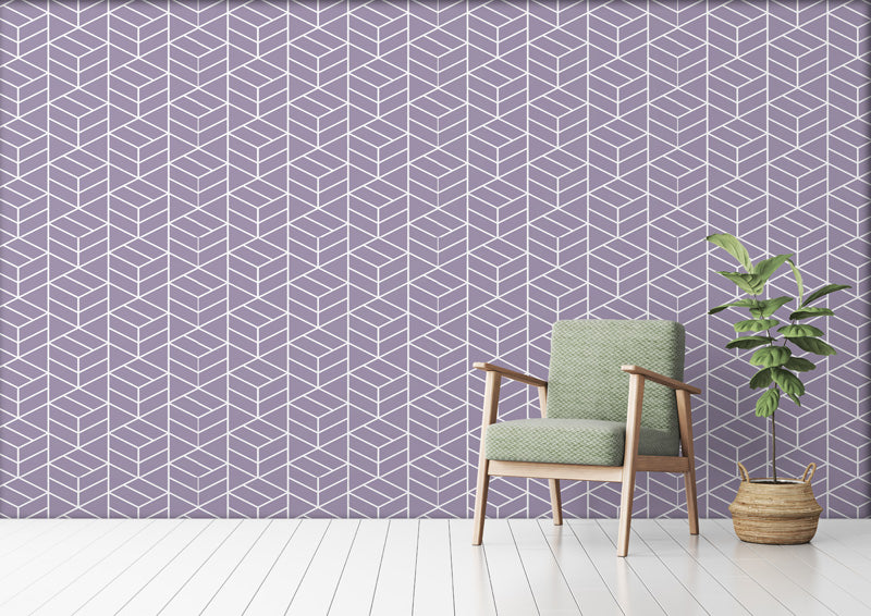 Green armchair and plant against a geometric wallpaper.