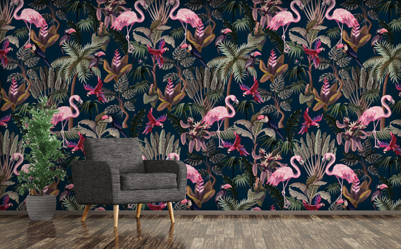 Living room with a blue wallpaper featuring a colorful flamingo and jungle leaf pattern, a gray armchair, and a potted plant.