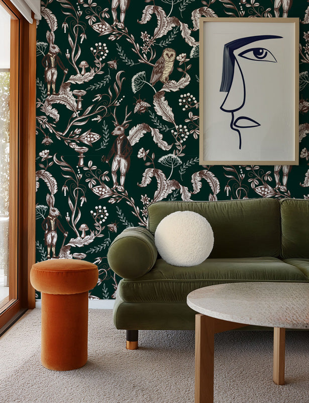 Living room with green sofa, orange stool, and framed artwork against a dark floral wallpaper.