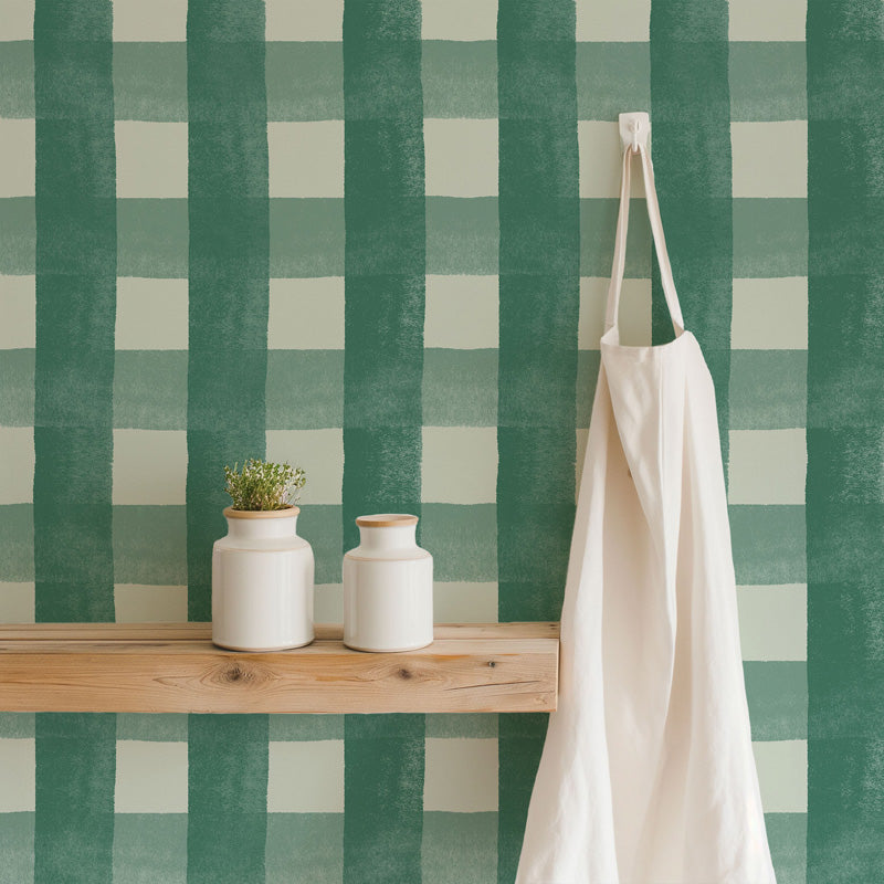 Green and white checkered wallpaper with a wooden shelf, white vases, and a white apron.