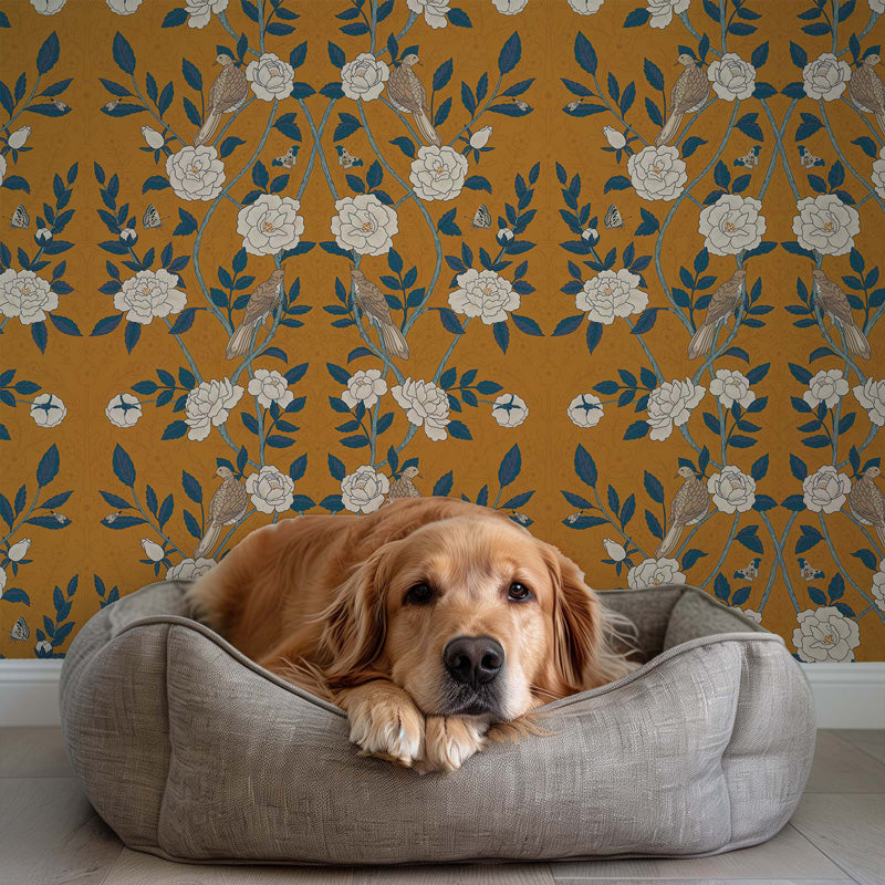 Dog lying in a gray pet bed against a decorative yellow wallpaper.