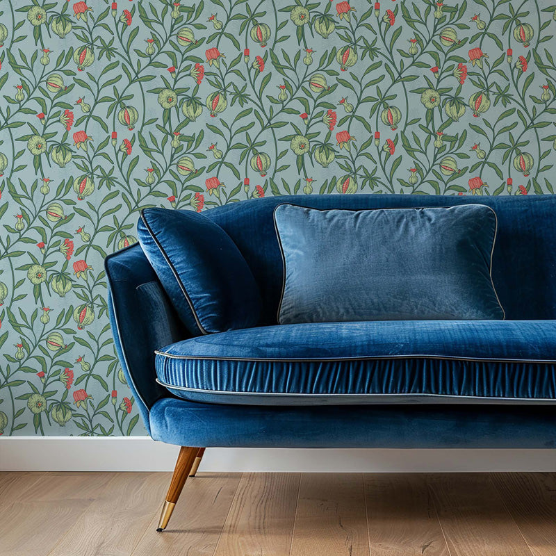Blue velvet sofa against a floral wallpaper.