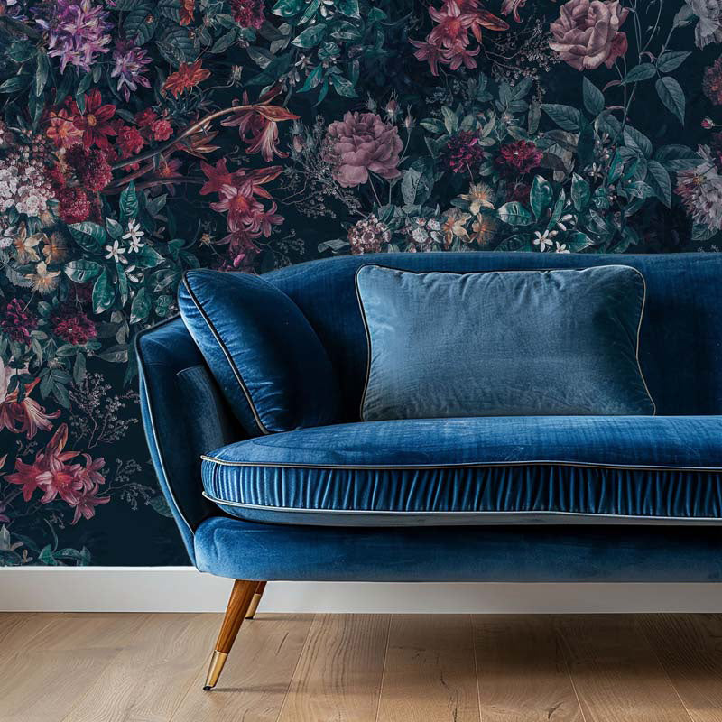 Blue velvet sofa against a floral wallpapered wall
