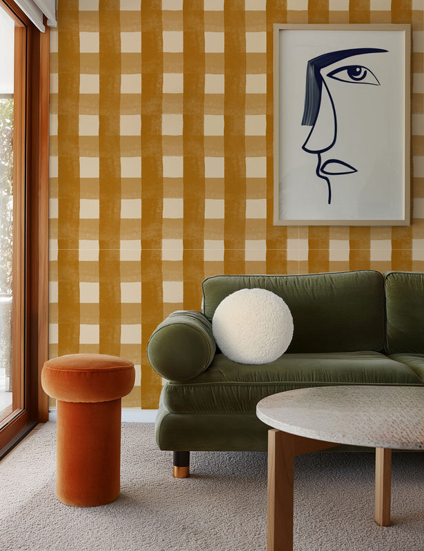 Living room with green sofa, orange stool, and checkered wallpaper.