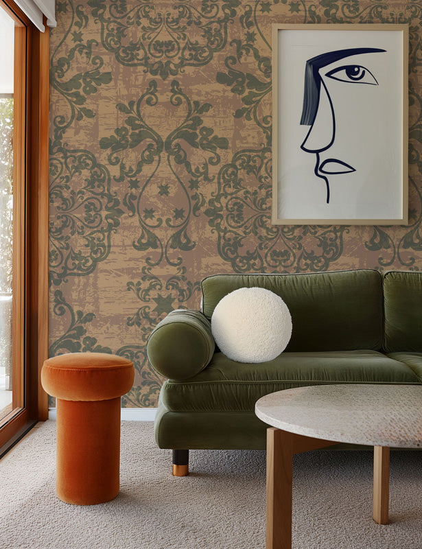 Living room with green sofa, orange stool, and abstract art on damask wallpaper.
