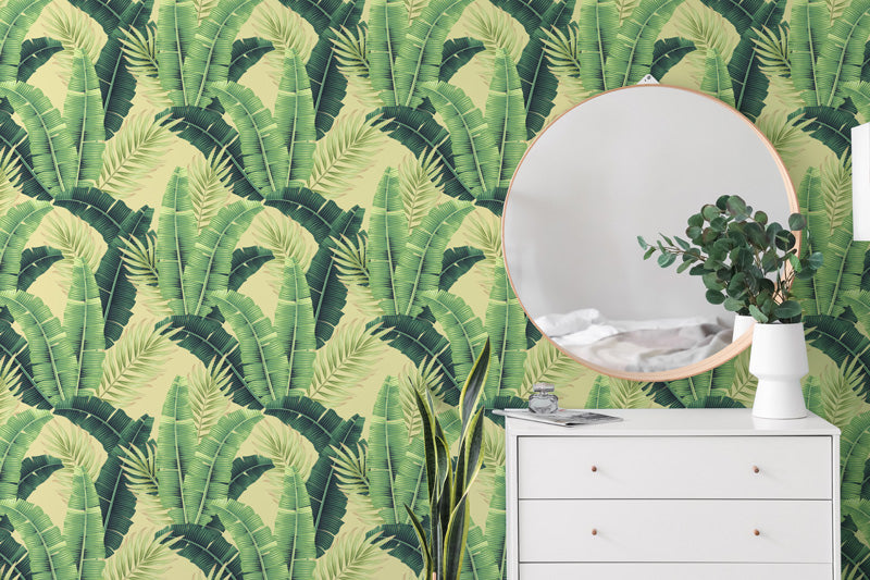 White dresser with round mirror against a green wallpaper.