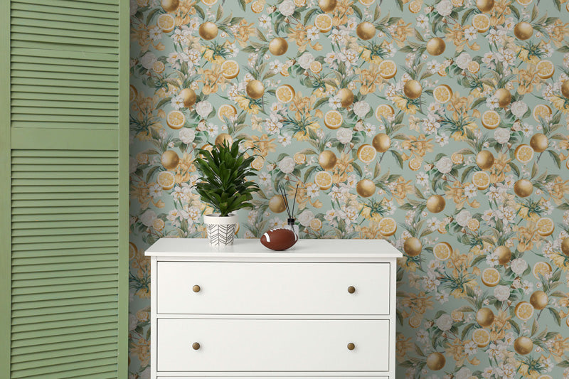 White dresser against a wall with lemon and green floral wallpaper