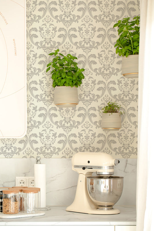 Kitchen scene with a stand mixer, plants, and decorative classic wallpaper.