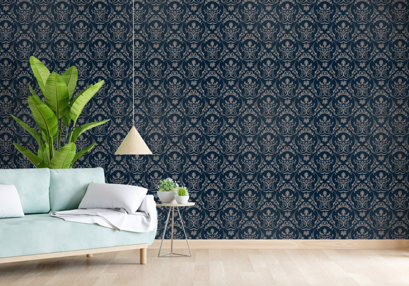 Living room with blue patterned wallpaper, light blue sofa, and decorative plants.