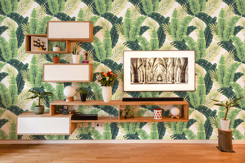 Living room with wooden shelves against a green leaf wallpaper.