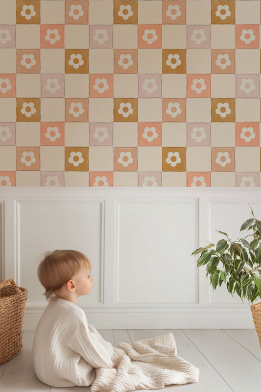 Child sitting on the floor in a room with floral wallpaper.