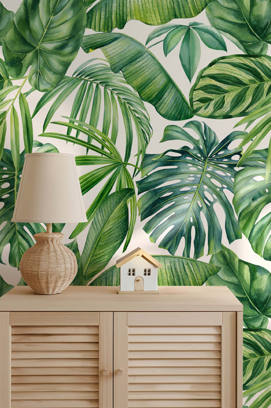 Tropical leaf wallpaper with a wooden cabinet and lamp in the foreground