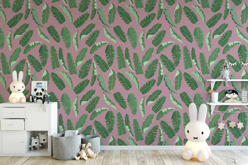 Children's room with pink wallpaper featuring green leaf pattern, white furniture, and toys.