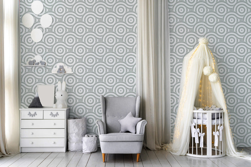 Children's room with gray wallpaper, crib, and gray armchair.