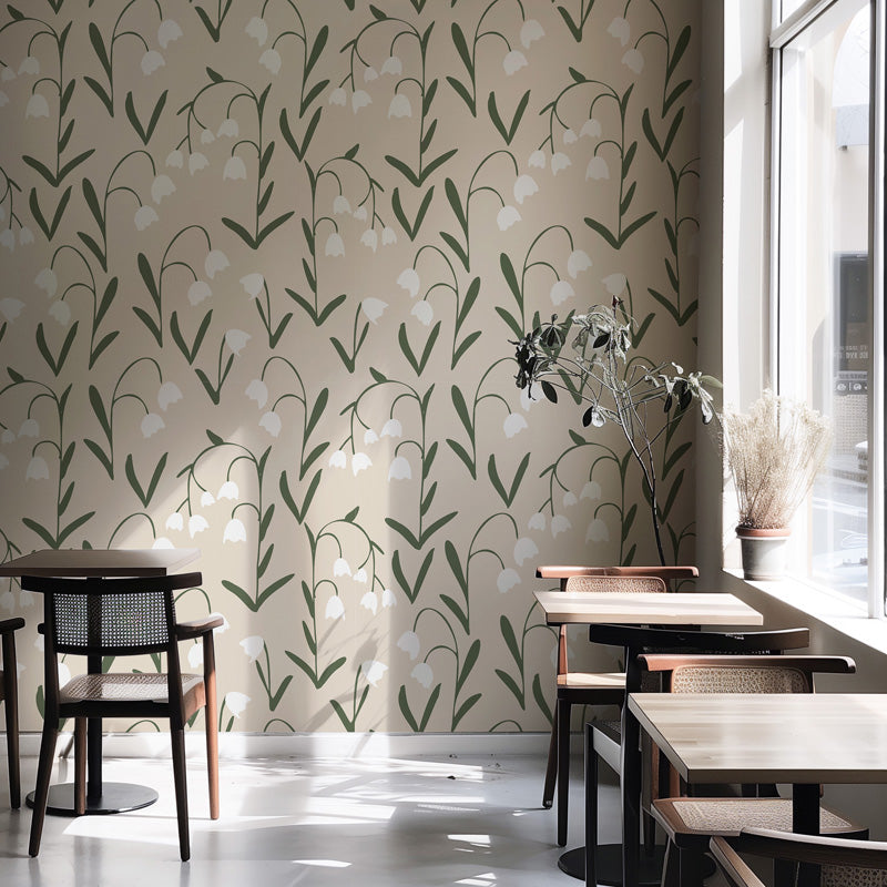 Restaurant interior with floral wallpaper, tables, and chairs near a window.