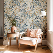 Living room with blue floral wallpaper, armchair, side table, and lamp.