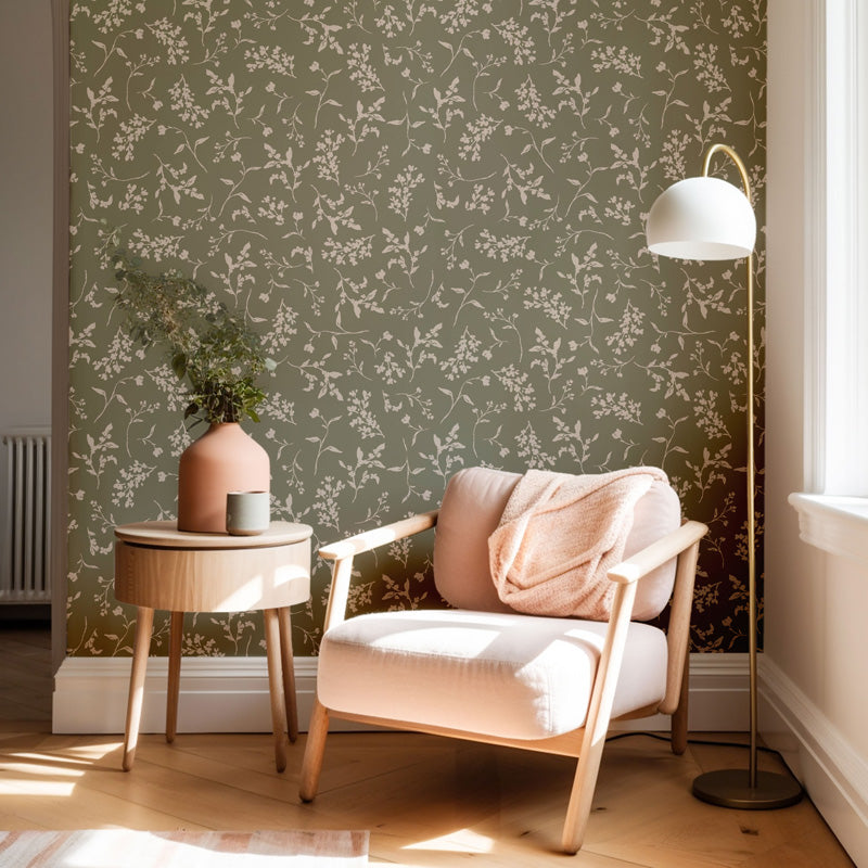 Modern living room with a green floral wallpaper, pink armchair, and side table.