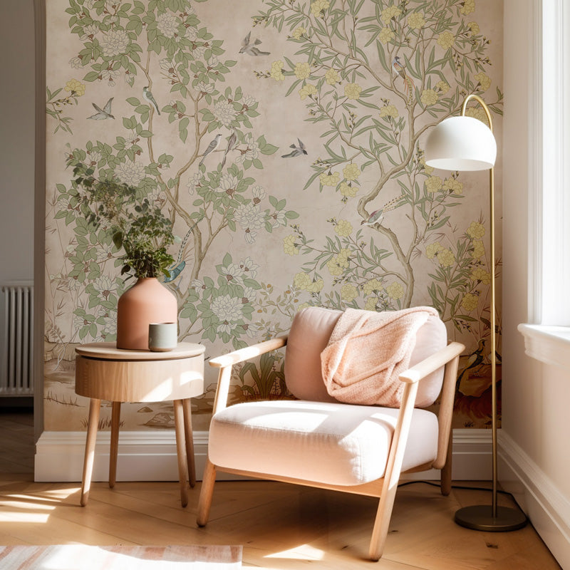 Cozy corner with a pink armchair, side table, and chinoiserie wallpaper.