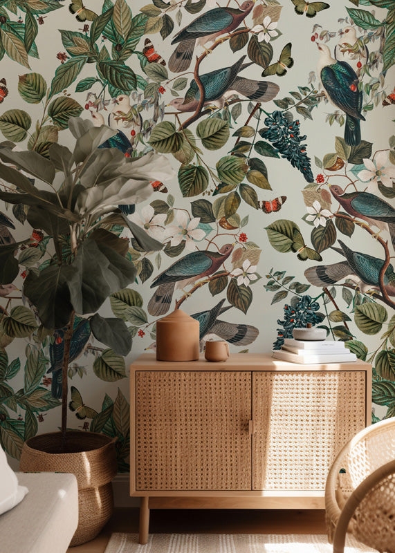 Room interior with wicker cabinet against a wall with nature wallpaper featuring birds and foliage.