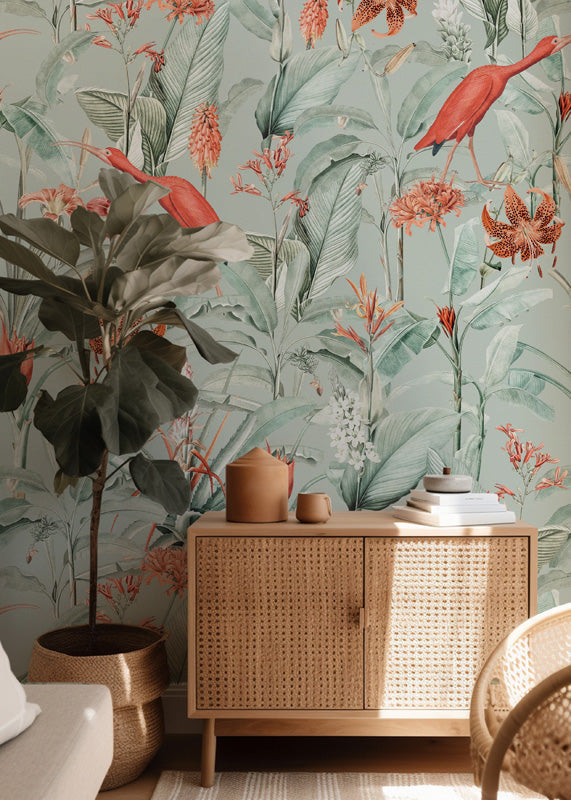 Tropical wallpaper with birds and plants, wooden cabinet, and decorative items.