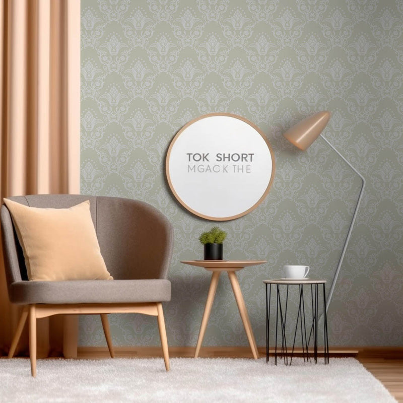 Modern living room with a gray armchair, round mirror, and decorative classic wallpaper.