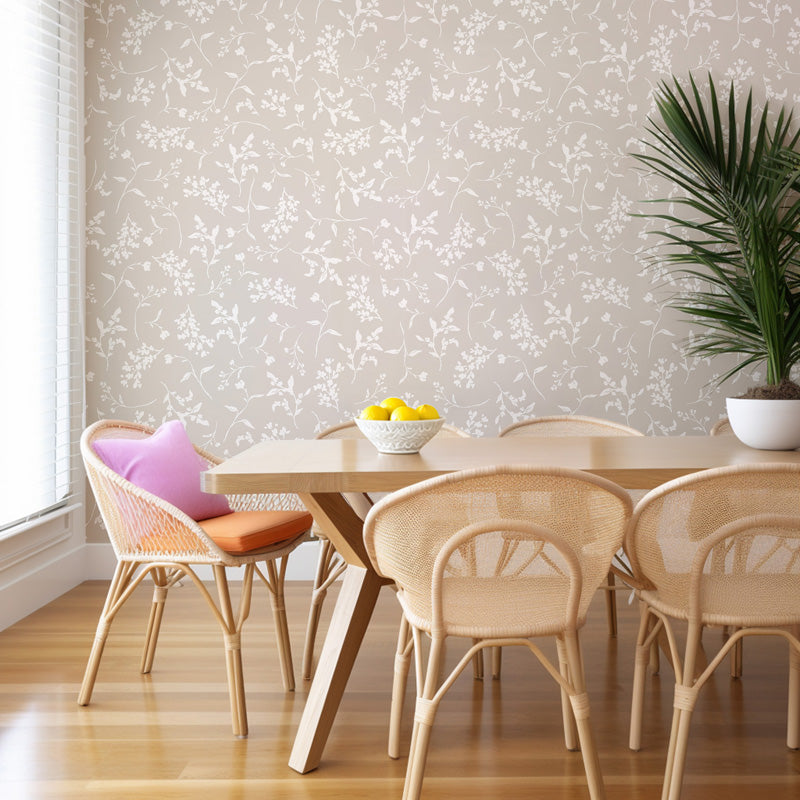 Dining area with a wooden table and chairs against a floral wallpaper wall.