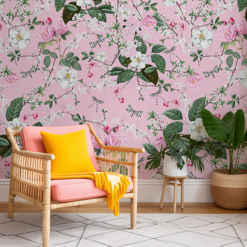 Pink armchair with yellow cushion against a floral pink wallpaper.