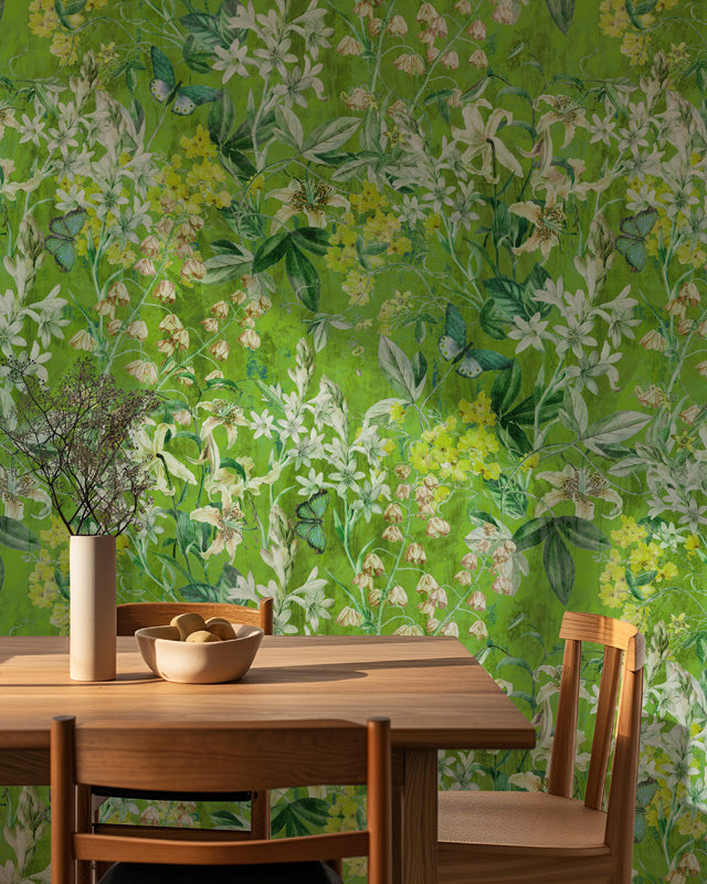 Dining area with wooden table and chairs against a green floral wallpaper.