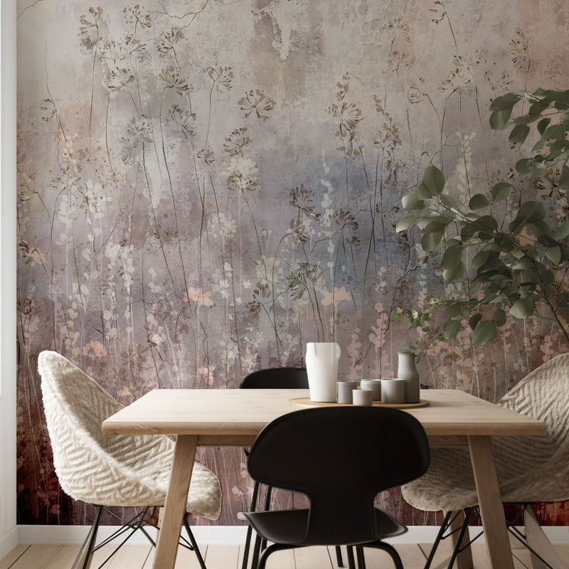 Dining area with a wooden table and chairs against a floral wallpaper wall.