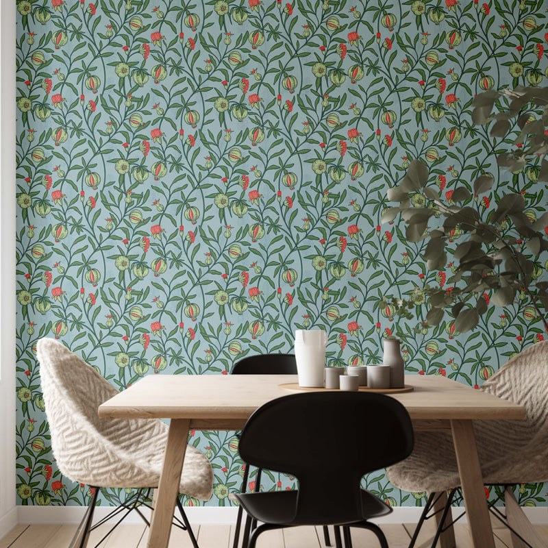 Dining area with a table and chairs against a floral wallpapered wall.