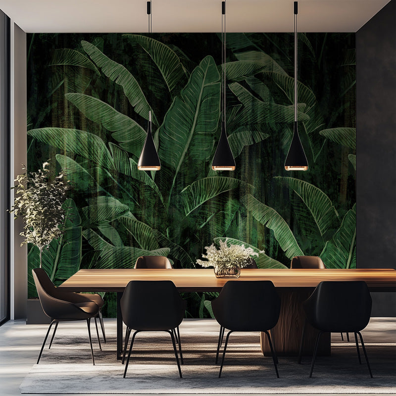 Dining area with a large green wall mural of leaves and a wooden table with chairs.