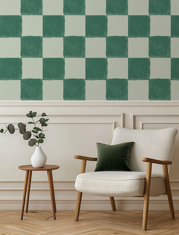 Modern living room with a checkered green and white wallpaper, a cream armchair, wooden side table, and decorative elements.